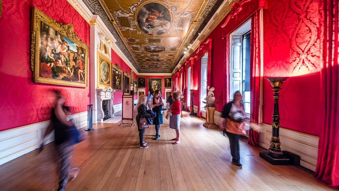 Visitors exploring the ornate gallery of Kensington Palace, London.