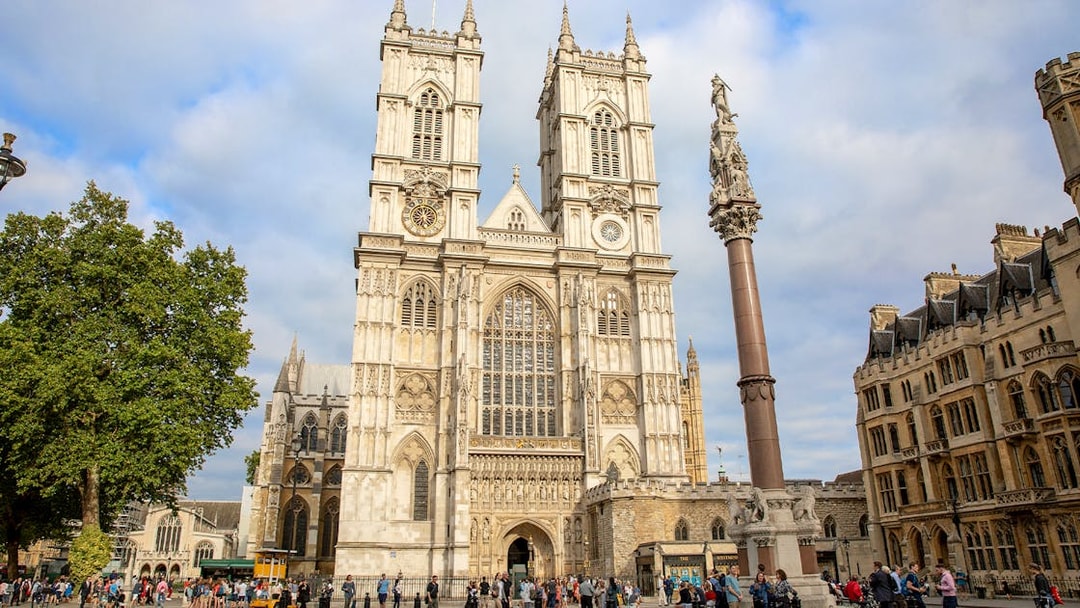 People gathered outside Westminster Abbey, London, admiring its Gothic architecture.
