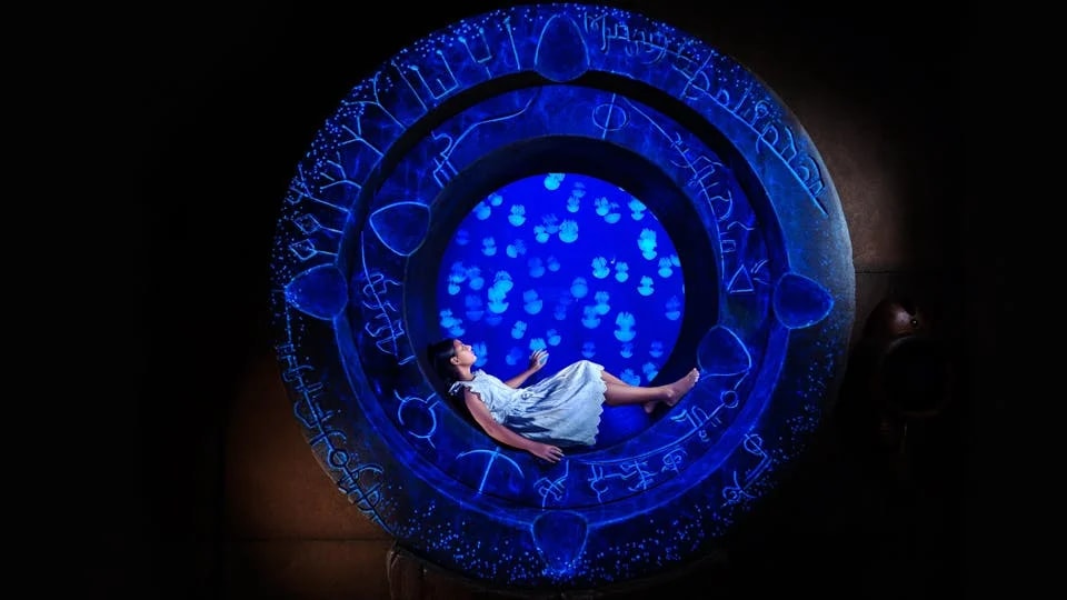 Girl inside illuminated portal at Atlantis The Lost Chambers Aquarium, Dubai.