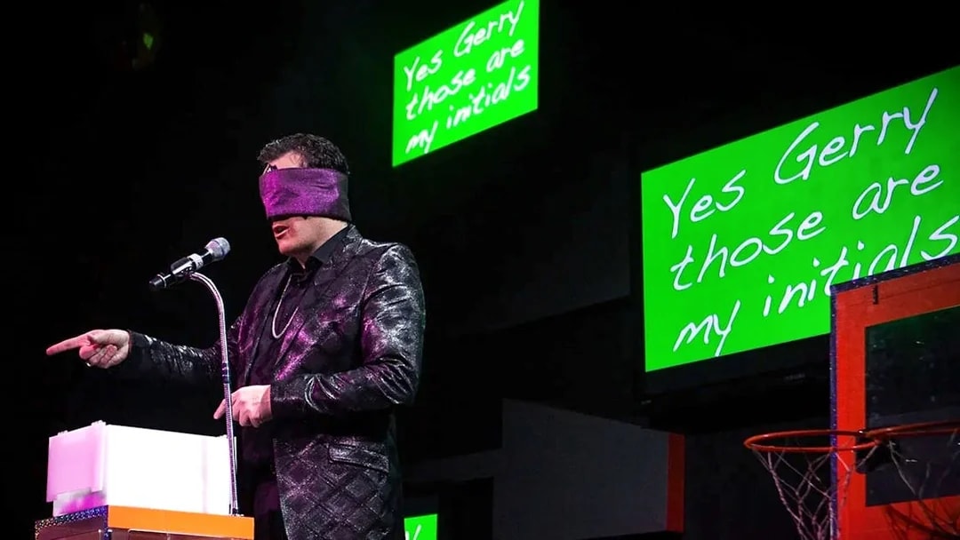 Performer blindfolded on stage during The Mentalist show, pointing at audience.