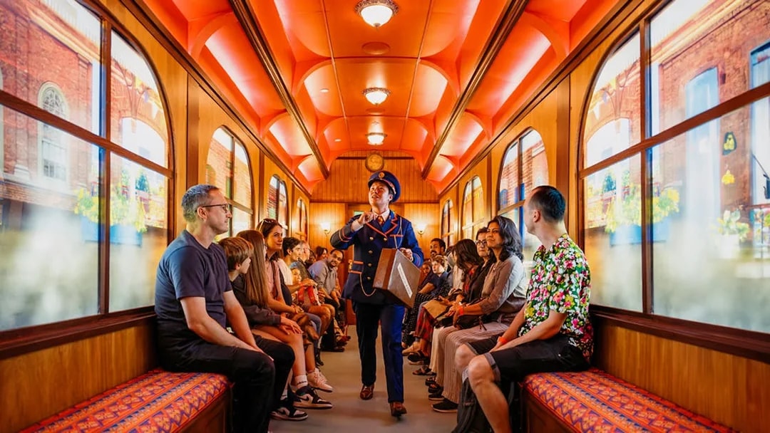 Children on a train during The Paddington Bear Experience in London, enjoying interactive storytelling.