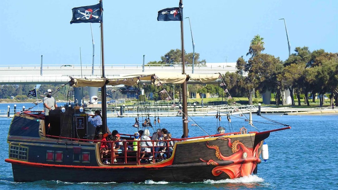 Pirate ship with passengers on Mandurah waters, featuring octopus design and pirate flags.