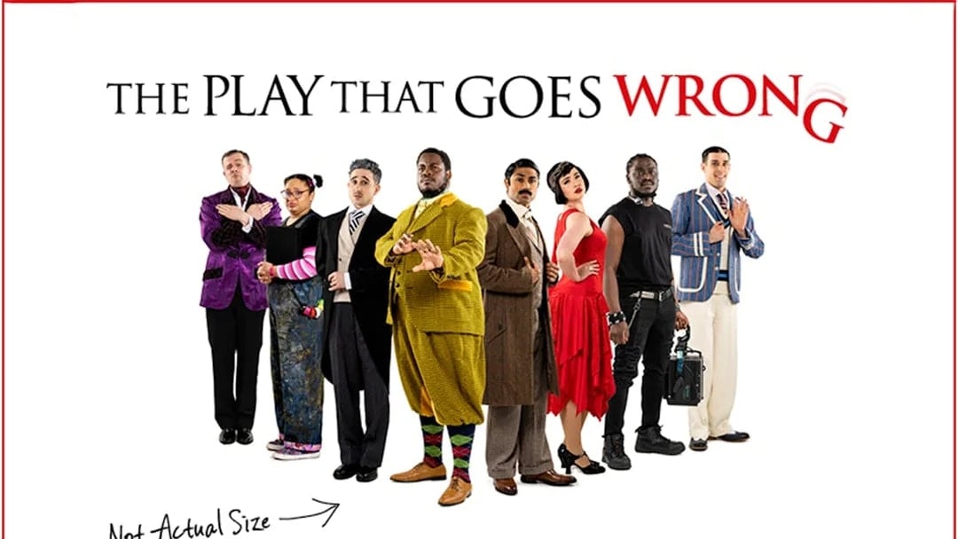 Cast of "The Play That Goes Wrong" in various costumes standing in a line.