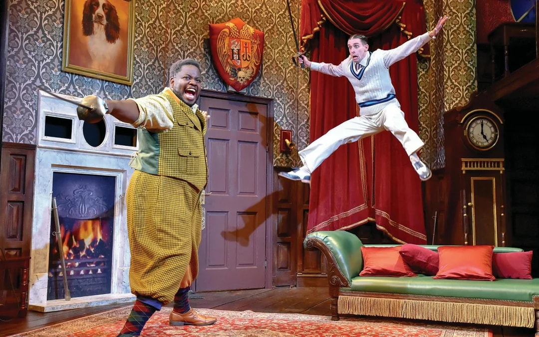Actors performing a comedic scene in "The Play That Goes Wrong" on stage.
