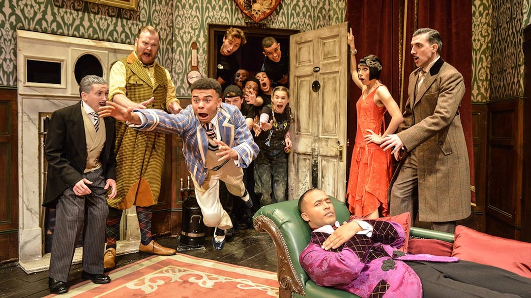 Actors performing a chaotic scene in "The Play That Goes Wrong" on stage.