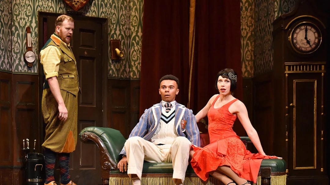 Actors in a comedic scene from "The Play That Goes Wrong" on stage.