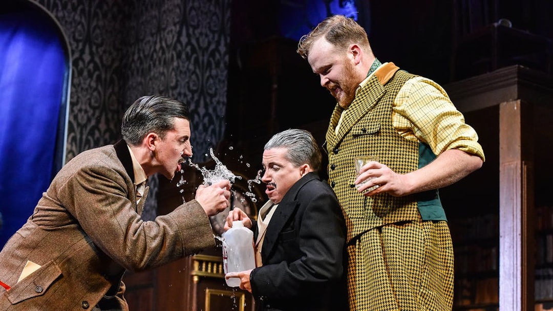 Actors in a comedic scene from "The Play That Goes Wrong" on stage.