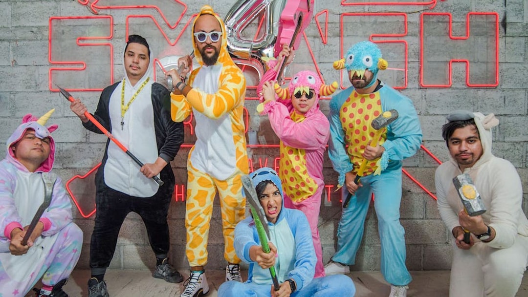 Visitors in costumes holding tools at Smash Room entrance.