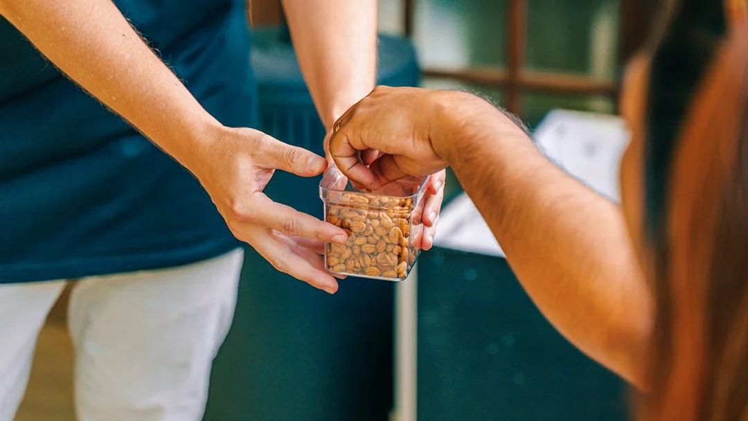 Hands exchanging a container of nuts during The Tastes of Tamborine Mountain tour.