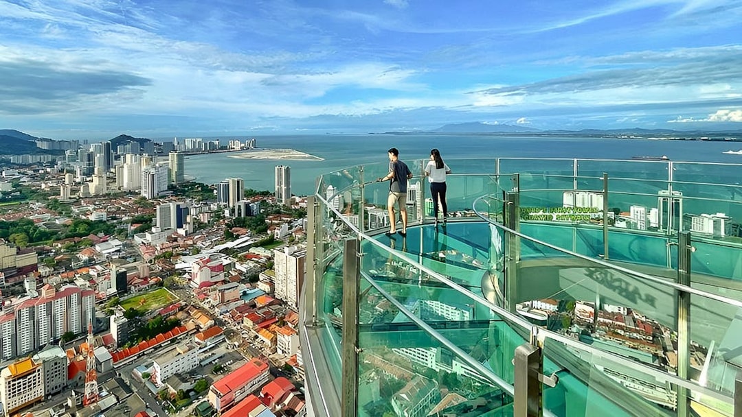 Couple enjoying city and sea view from The Top, Penang observation deck.