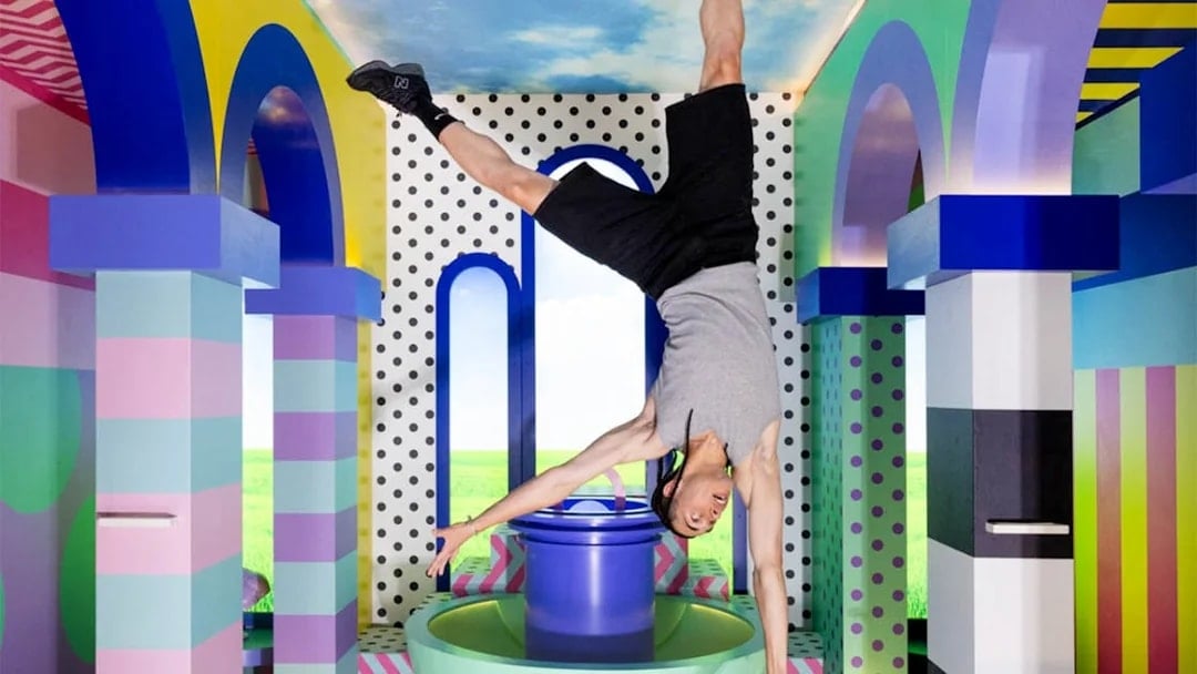 Person doing a handstand in colorful, upside-down room at The Upside Down Berlin.