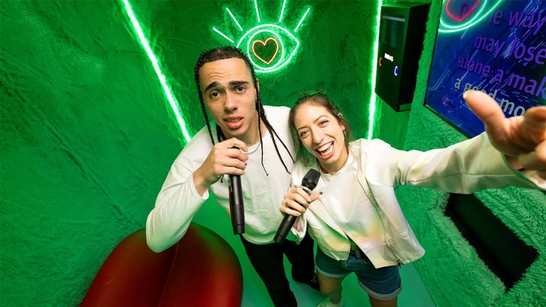 People singing karaoke at The Upside Down Berlin with neon lights.