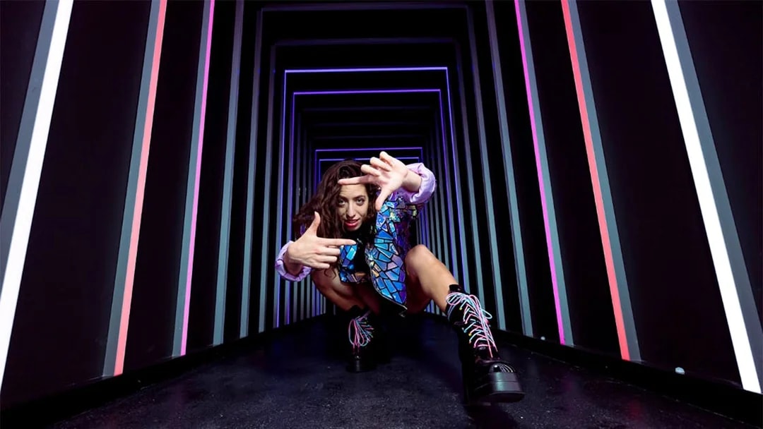 Person posing in a neon-lit tunnel at The Upside Down Berlin.