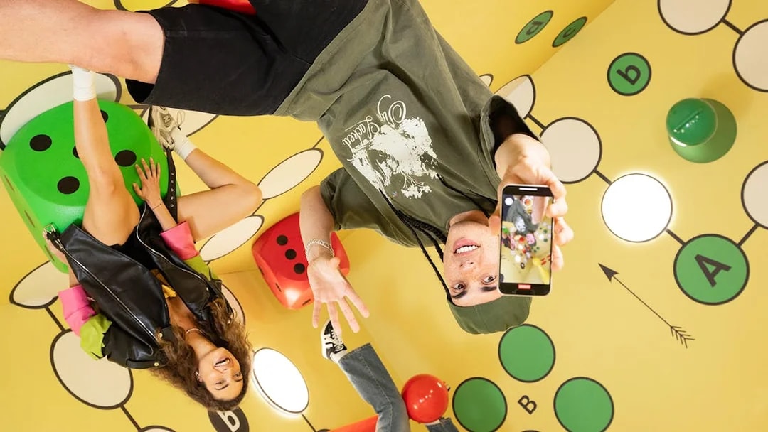 Visitors enjoying The Upside Down Berlin exhibit with colorful dice and playful decor.