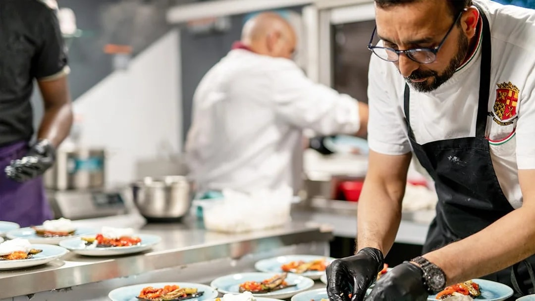 Chef preparing gourmet dishes for THEO Boat Brunch cruise in Paris.