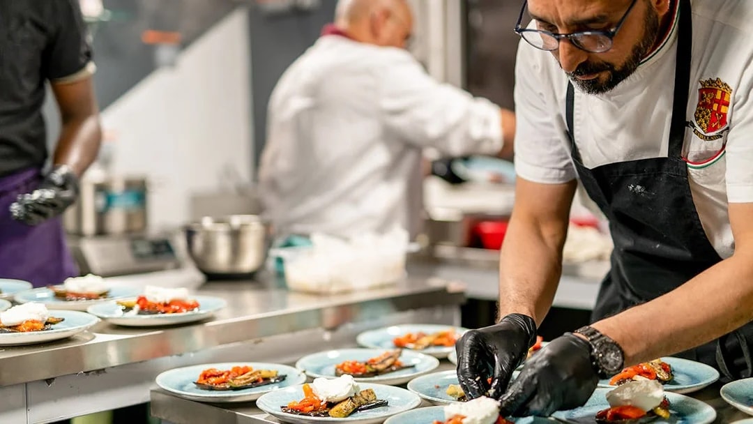 Chef preparing Italian dishes for Le Diamant Bleu dinner cruise in Paris.