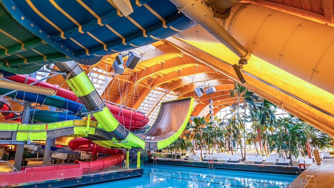 Therme Bucuresti indoor water slides and pool area with tropical plants.