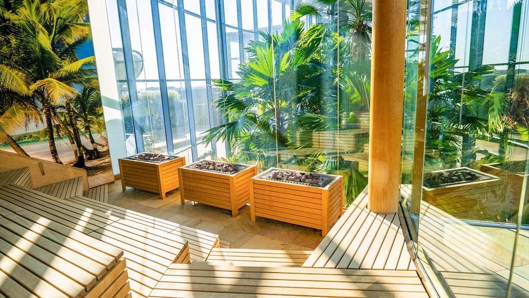 Therme Bucuresti indoor garden with tropical plants and wooden planters.