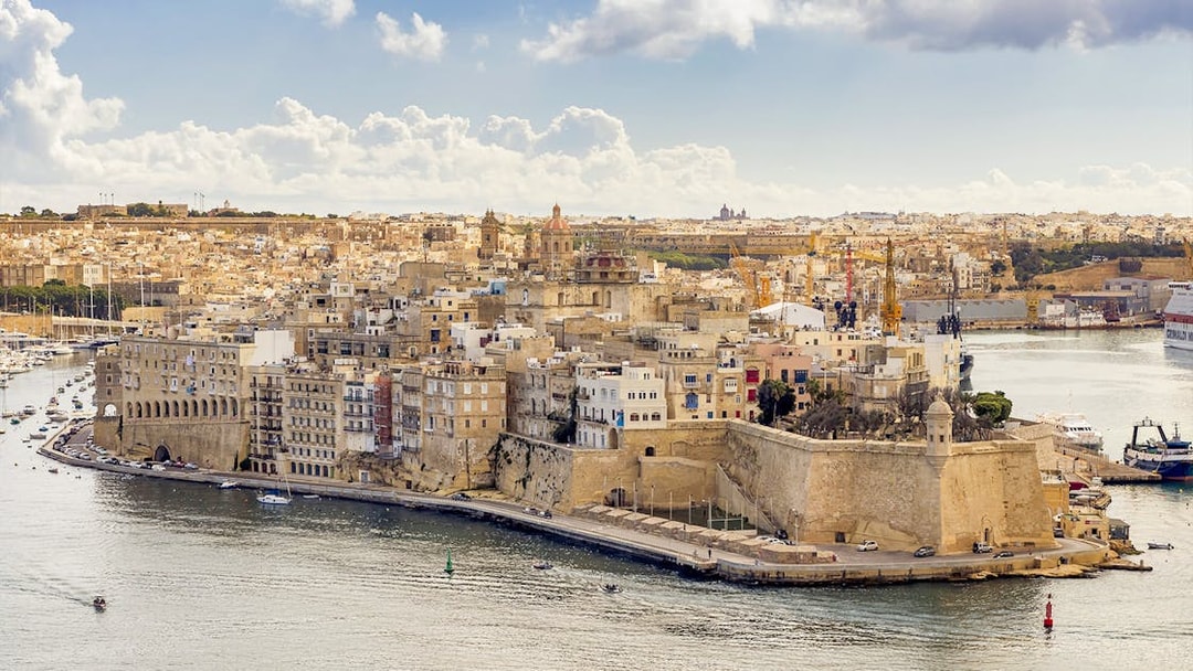 Aerial view of the Three Fortified Cities in Malta with boats in the harbor.