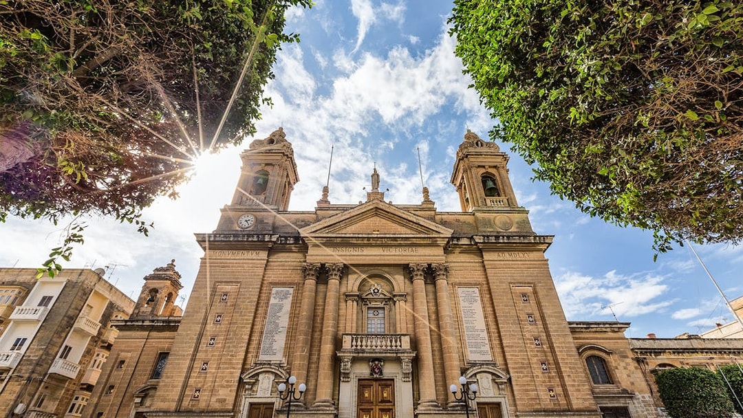 Historic building facade in one of the Three Fortified Cities, Malta, under a sunny sky.