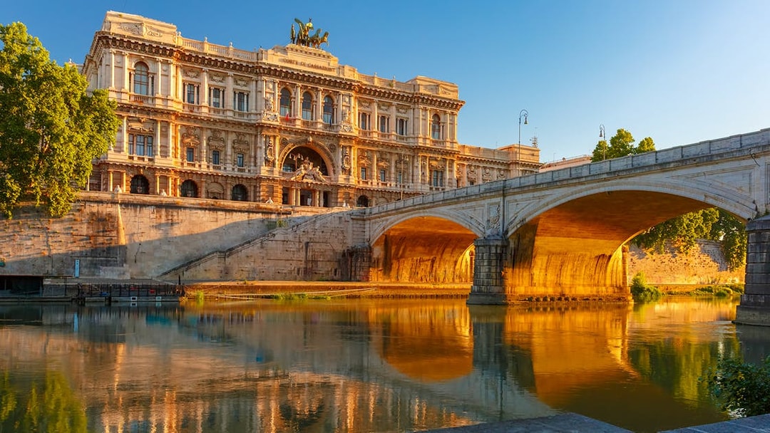 Palazzo di Giustizia and bridge over Tiber River in Rome at sunset.