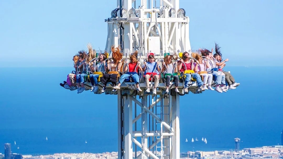 Visitors on the Merlin ride at Tibidabo Amusement Park with a view of Barcelona.