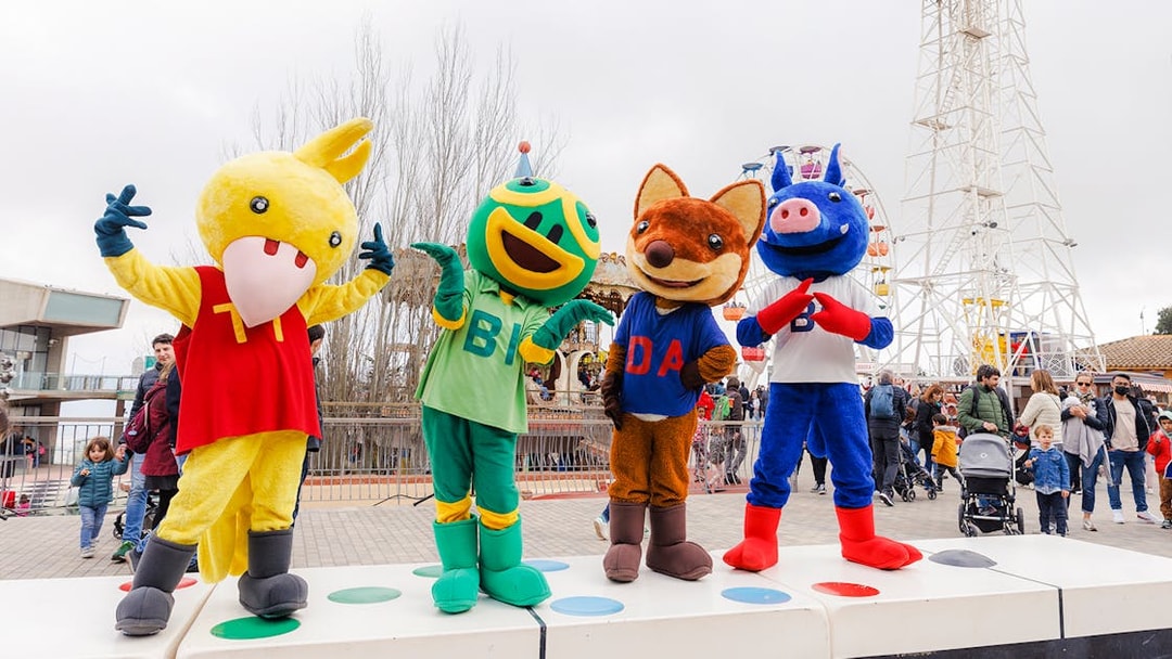 Mascots at Tibidabo Amusement Park in Barcelona with Ferris wheel in background.