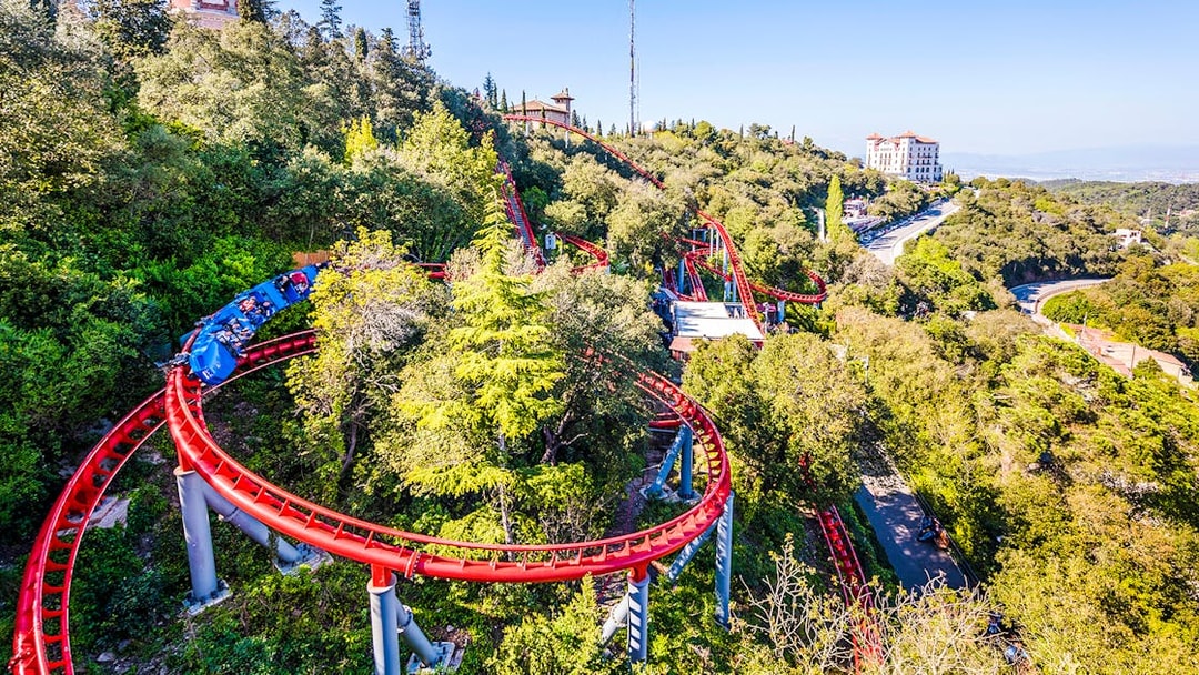 Roller coaster winding through trees at Tibidabo Amusement Park, Barcelona.