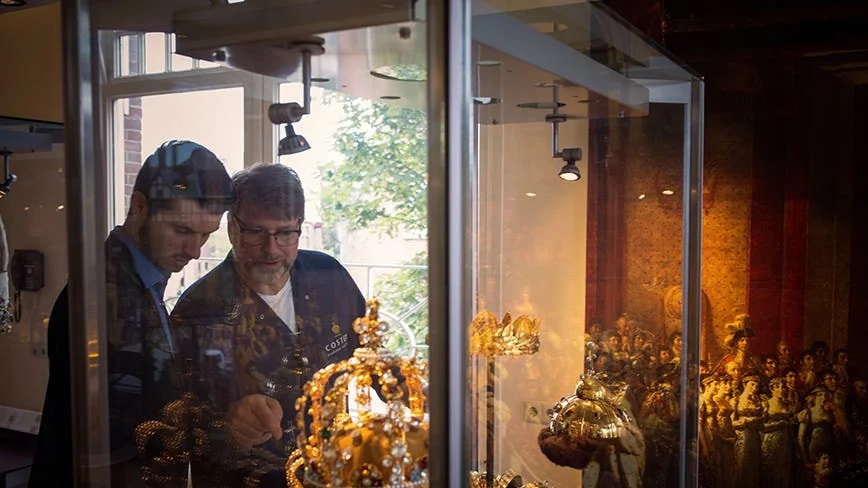 Visitors examining royal crowns at Diamond Museum Amsterdam.
