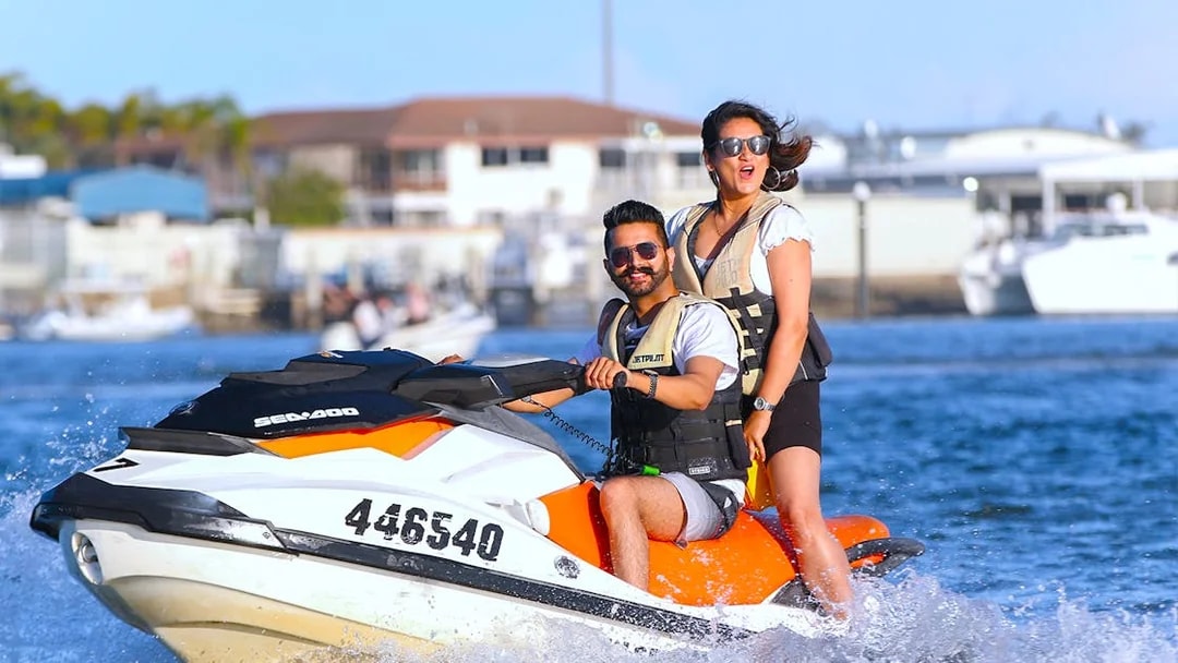 Jet skiing adventure with two people on a vibrant watercraft near a marina.
