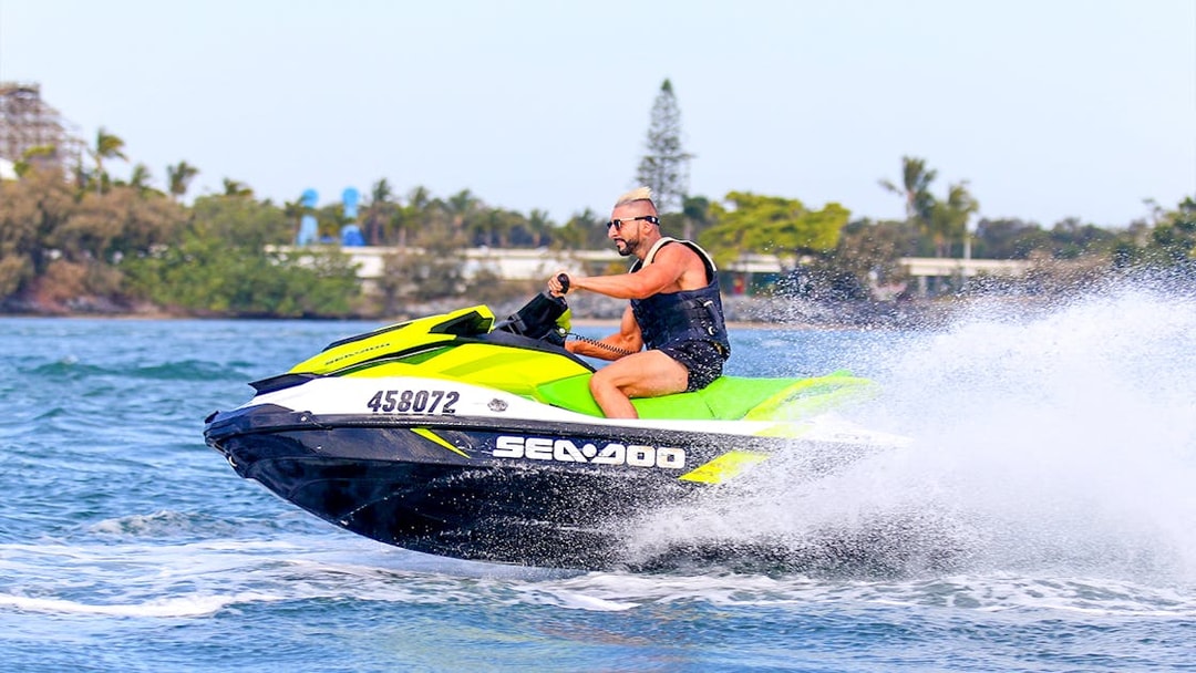 Person riding a jet ski on open water during a Jet Ski & Parasail Experience.