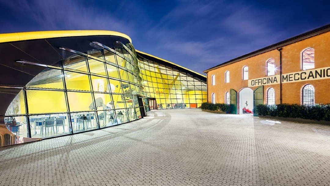 Museo Enzo Ferrari Modena entrance with modern glass facade and historic building.