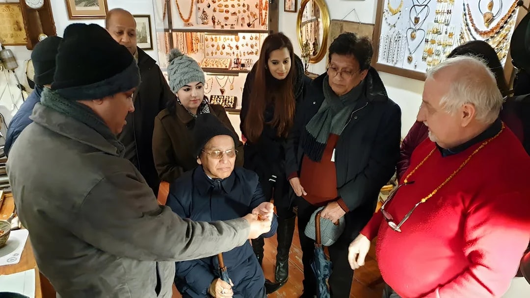 Group observing amber crafting demonstration at Gdańsk workshop.
