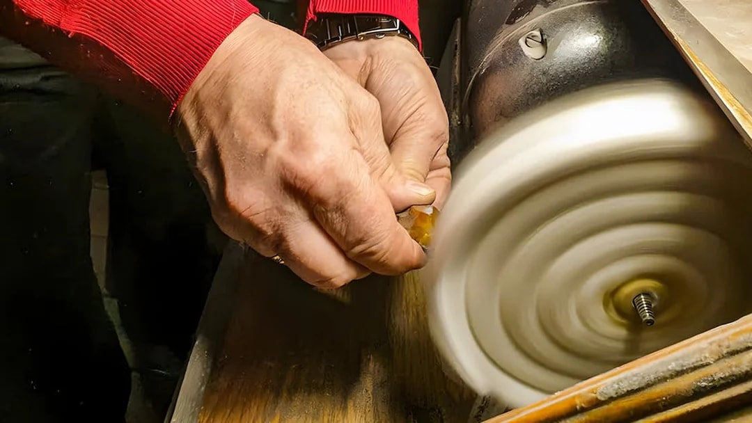 Hands polishing amber at Gdańsk workshop.