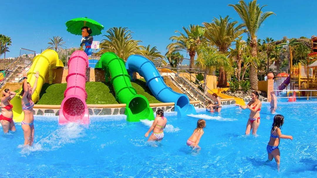 Children playing near colorful water slides at Aqualand Maspalomas.