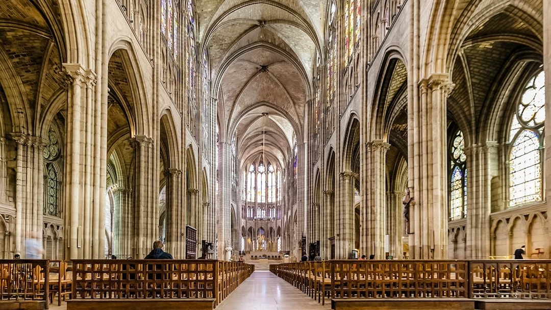 Interior view of Basilica of Saint-Denis with vaulted ceilings and stained glass windows.