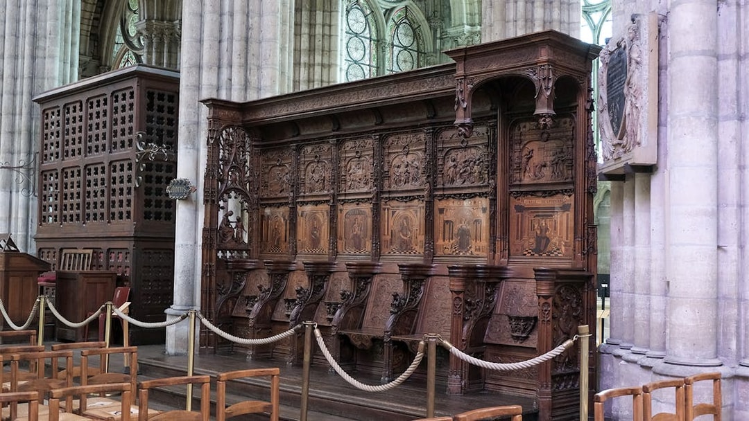Basilica of Saint-Denis interior with detailed wooden choir stalls and stained glass windows, Paris, France.