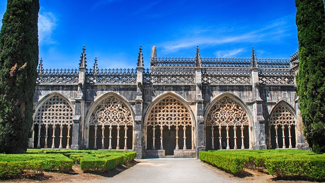 Batalha Monastery's ornate Gothic arches and manicured gardens in Portugal.