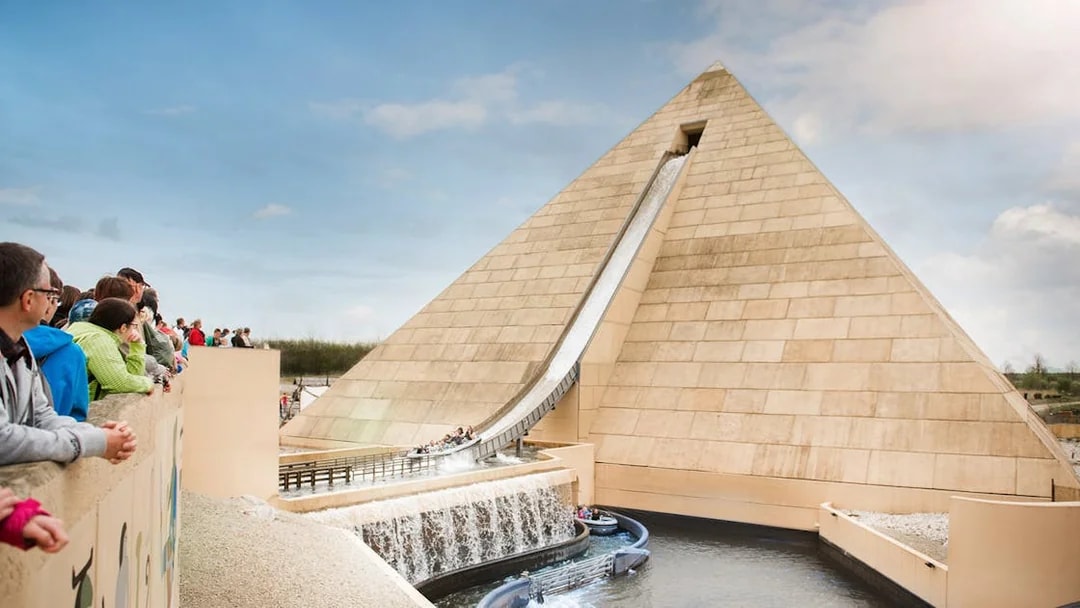 Visitors watching a water ride at Belantis Adventure Park with a pyramid backdrop.