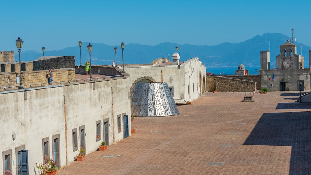 Courtyard of Castel Sant'Elmo in Naples with distant mountain view.