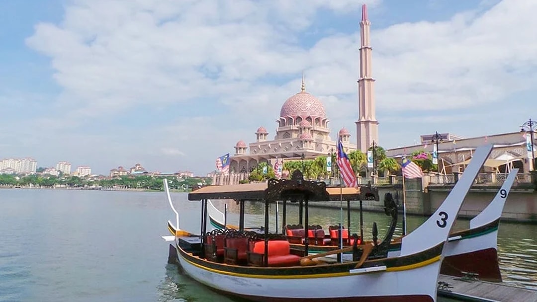 Cruise boat on Tasik Putrajaya with Putra Mosque in the background, Malaysia.