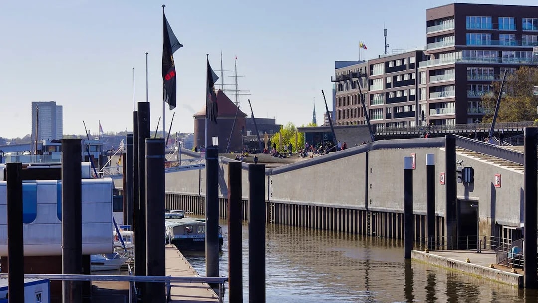 Harbor view in Hamburg with modern buildings and docked boats.