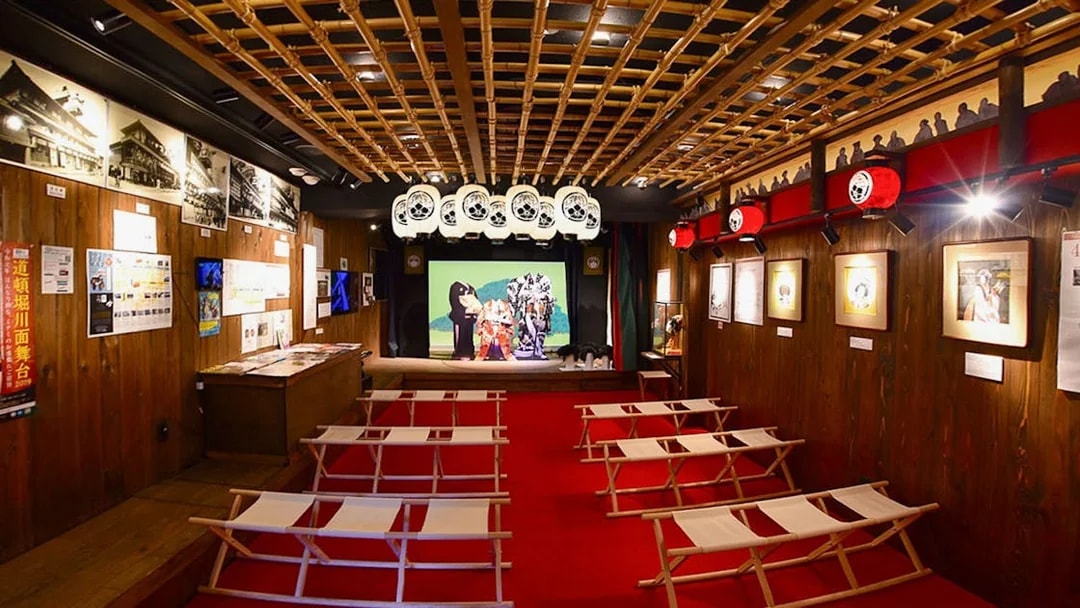 Interior of Osaka Dotonbori Museum Namikiza with traditional seating and stage display.