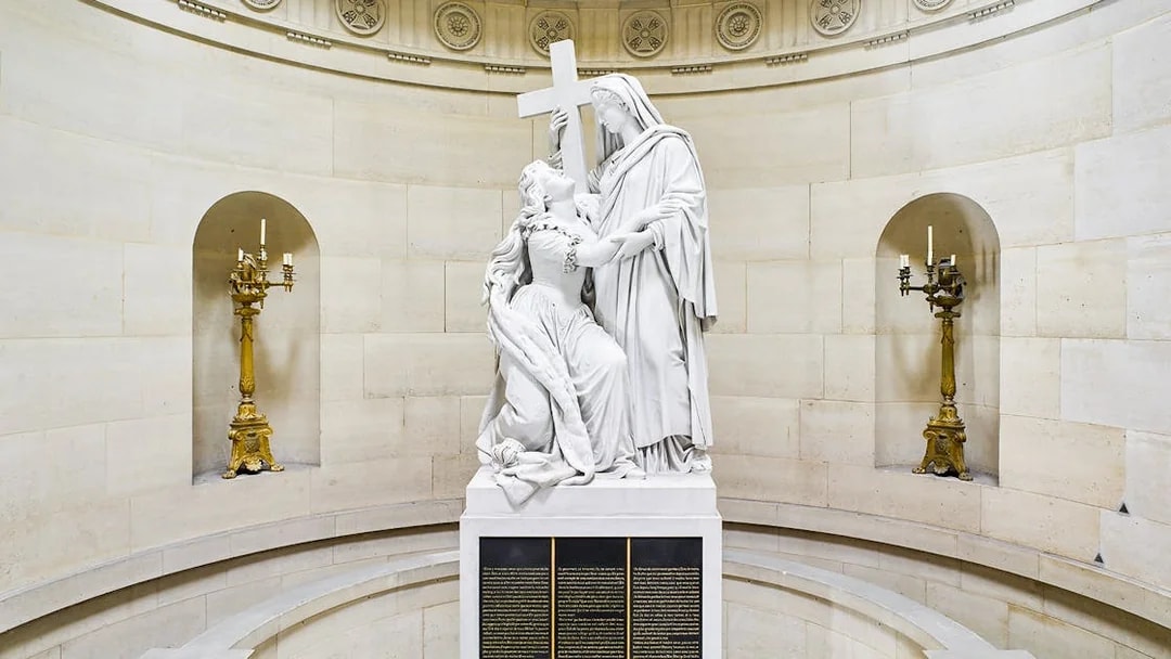 Statue inside Expiatory Chapel, Paris, depicting a kneeling figure holding a cross.