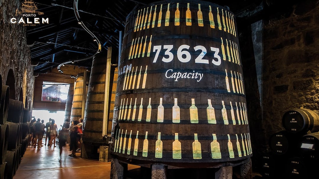 Porto wine cellar with large barrels, venue for Fado concert tickets.