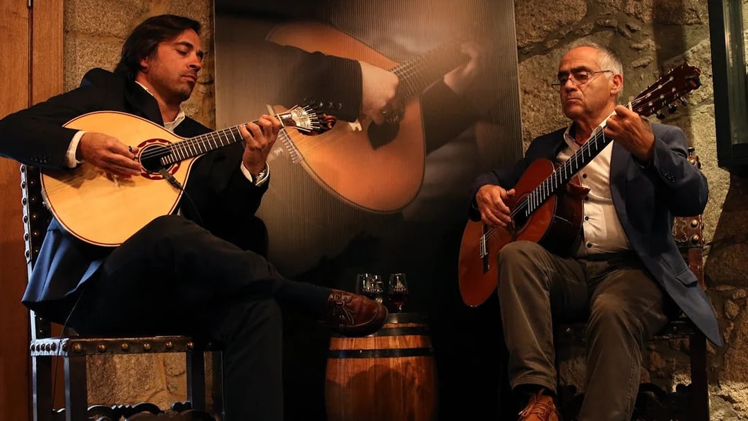 Musicians playing guitars at a Fado concert in a Port wine cellar.