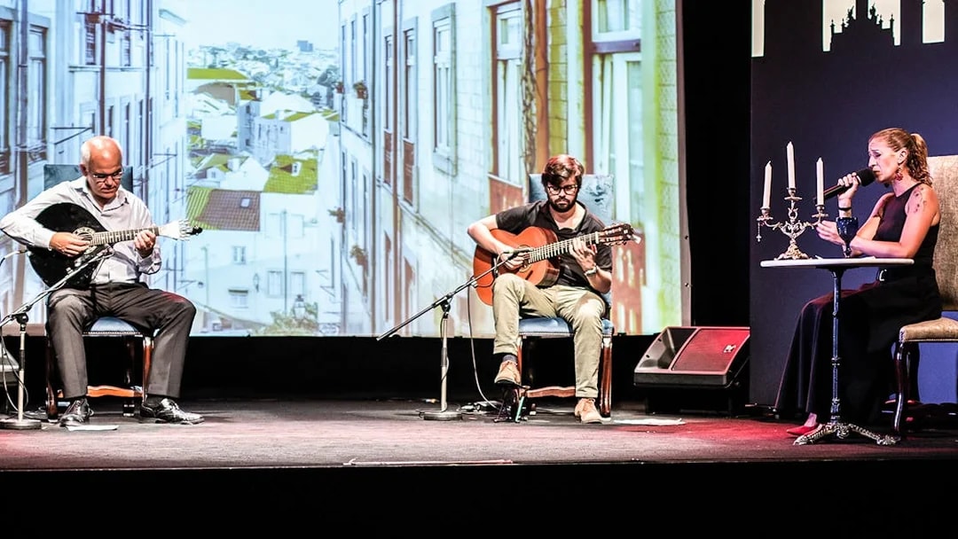 Musicians performing Fado in Chiado, Lisbon, with a backdrop of city buildings.