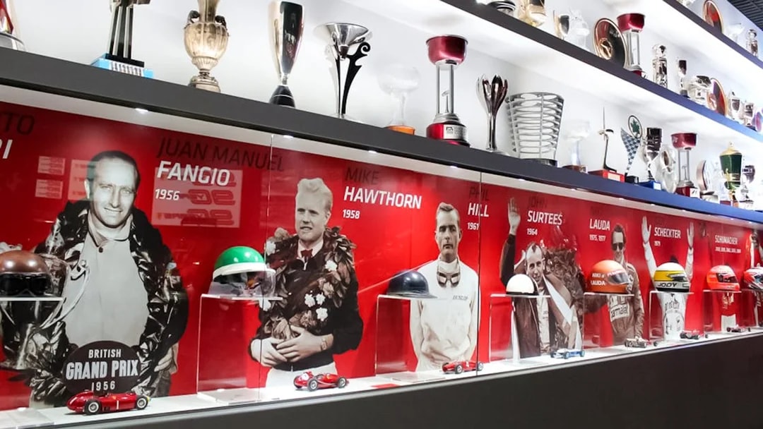 Ferrari Museum Maranello display of racing trophies and driver portraits.