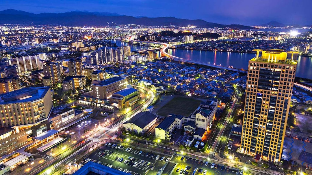 Fukuoka cityscape at night with illuminated buildings and river view from Fukuoka Tower.