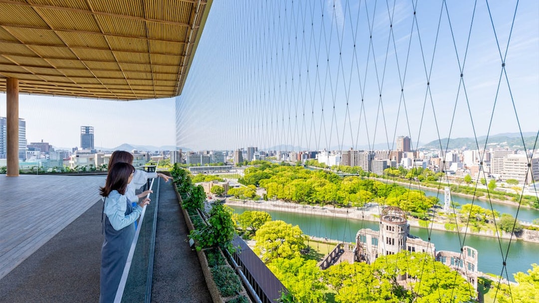 Visitors enjoying the view from Hiroshima Orizuru Tower overlooking the Atomic Bomb Dome and cityscape.